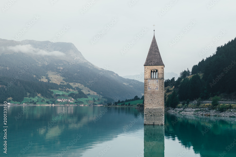 Beautiful view of the lake Resia. Famous tower in the water. Alps, Italy, Europe. Landscape photography