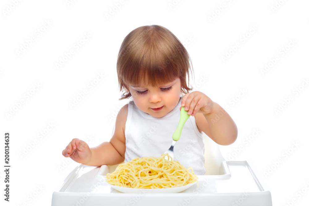 a handsome baby 1.6 years old sits in a white child's highchair. The concept of baby food. Food. a handsome baby 1.6 years old sits in a white child's highchair. The concept of baby food. Food.