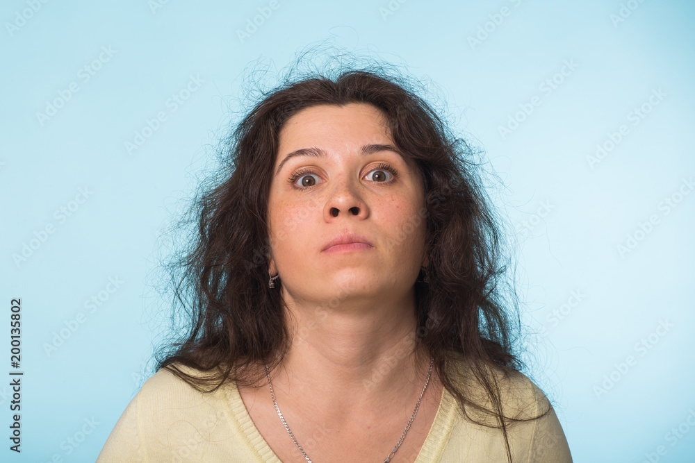 Close up portrait of a beautiful young woman with curly hair on blue background