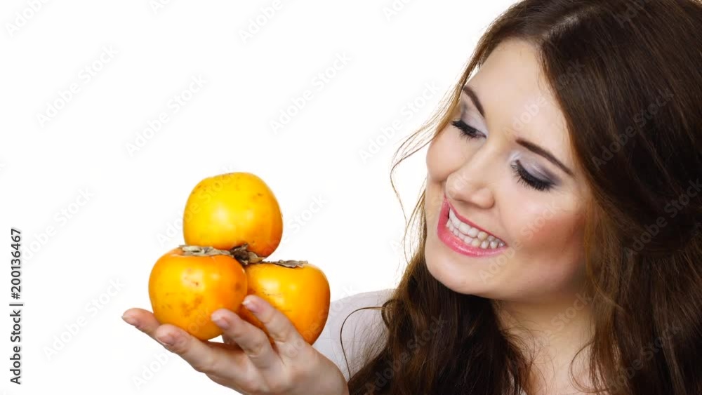 Woman toothy smile brunette girl holding persimmon kaki fruits in hands, isolated on white. Healthy eating, vegetarian food, diet concept. Woman toothy smile brunette girl holding persimmon kaki fruits in hands, isolated on white. Healthy eating, vegetarian food, diet concept.