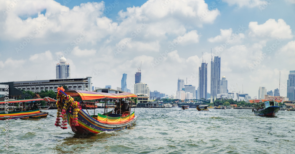 Tourist popular boat travel on the Chao Phraya river. To stay in downtown Bangkok. King Rama I Memorial Bridge and skyscrapers of Chinatown is seen on the horizon - obrazy, fototapety, plakaty 