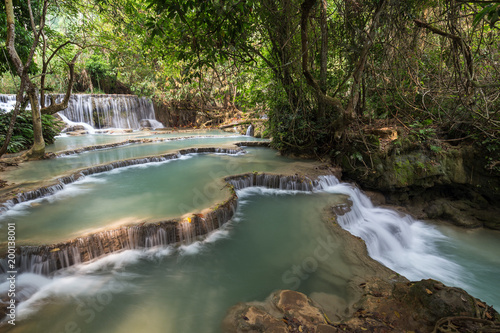 Beautiful view of a small waterfall and cascades at the Tat Kuang Si Waterfalls near Luang Prabang in Laos on a sunny day.