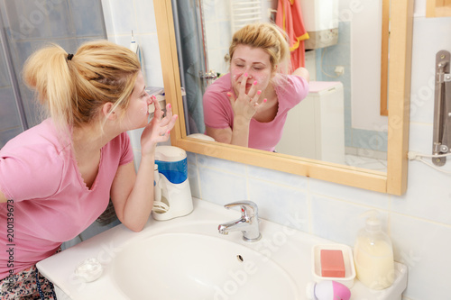 Woman applying face cream with her finger