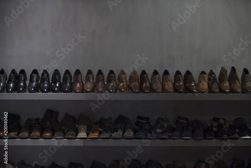 Shelves with brown and black mens shoes. Row of leather mens shoes. Mens shoes, boot sell in store, boutique, shopping mall. Mens shoes concept. Mens fashion, style, quality, leather, leatherette. photo