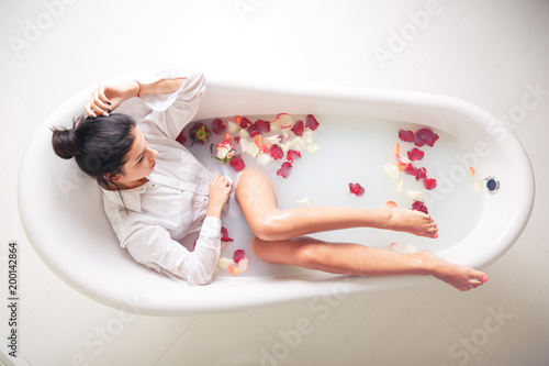 A young brunette woman takes a milk bath.