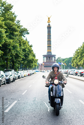 Tourist in Berlin riding scooter in dense traffic