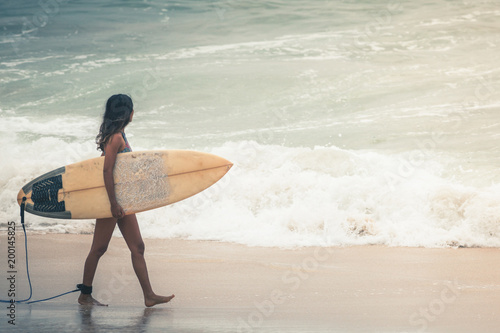 Surfer with surfboard gonna to surf spot, walk near beach.