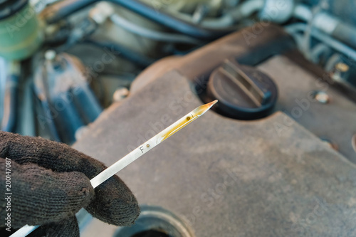 checking the oil level in a car engine