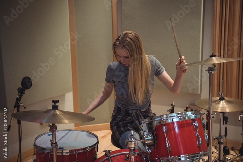 Female drummer playing a playing music on drum set photo