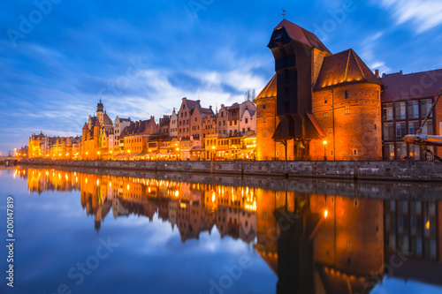 Historic port crane in Gdansk reflected in Motlawa river at dusk, Poland