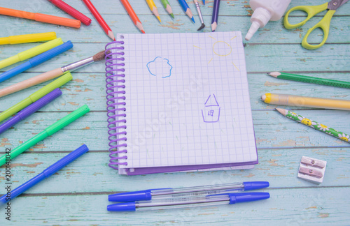 School supplies. Color pencils,note book, blue pens, sciccors, markers, glue, pencil sharpener, clips photo