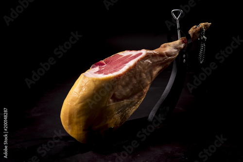Dry Spanish ham, Jamon Serrano, Italian prosciutto crudo or Parma ham, whole leg isolated on black background