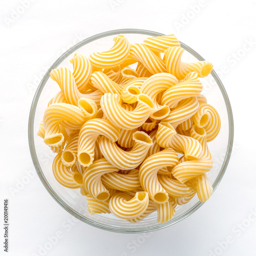 cavatappi pasta in glass bowl on white isolated background. photo