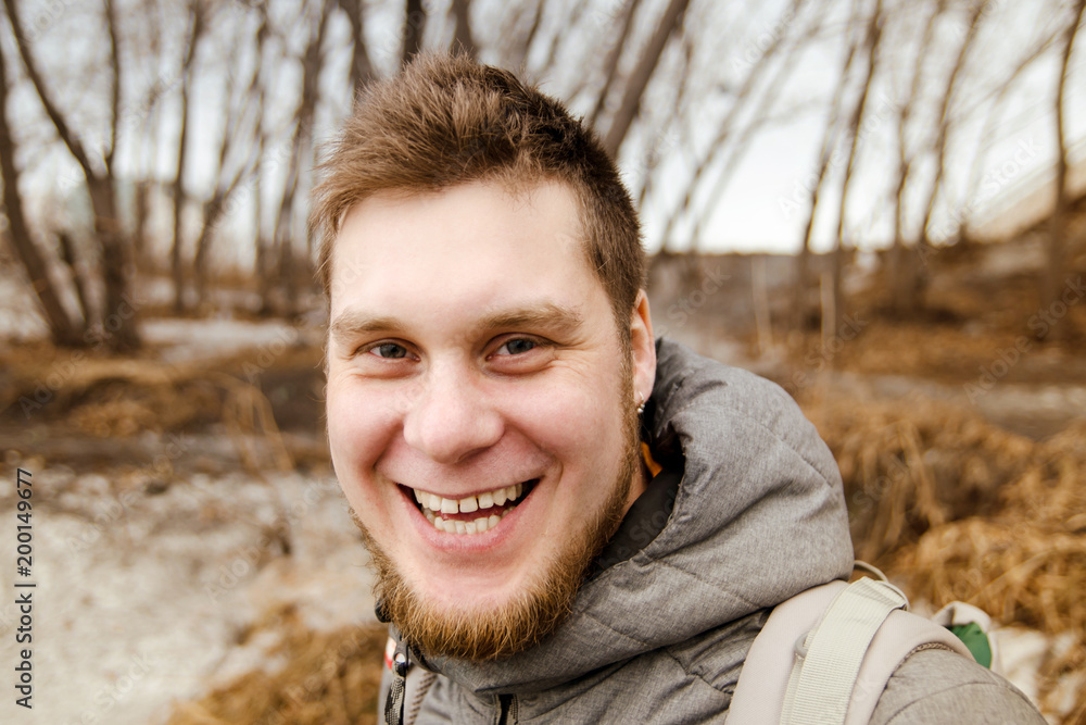 Ginger smiling young guy with beard on nature background. Ginger smiling young guy with beard on nature background.