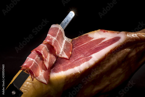 Dry Spanish ham, Jamon Serrano, Italian prosciutto crudo or Parma ham, whole leg isolated on black background