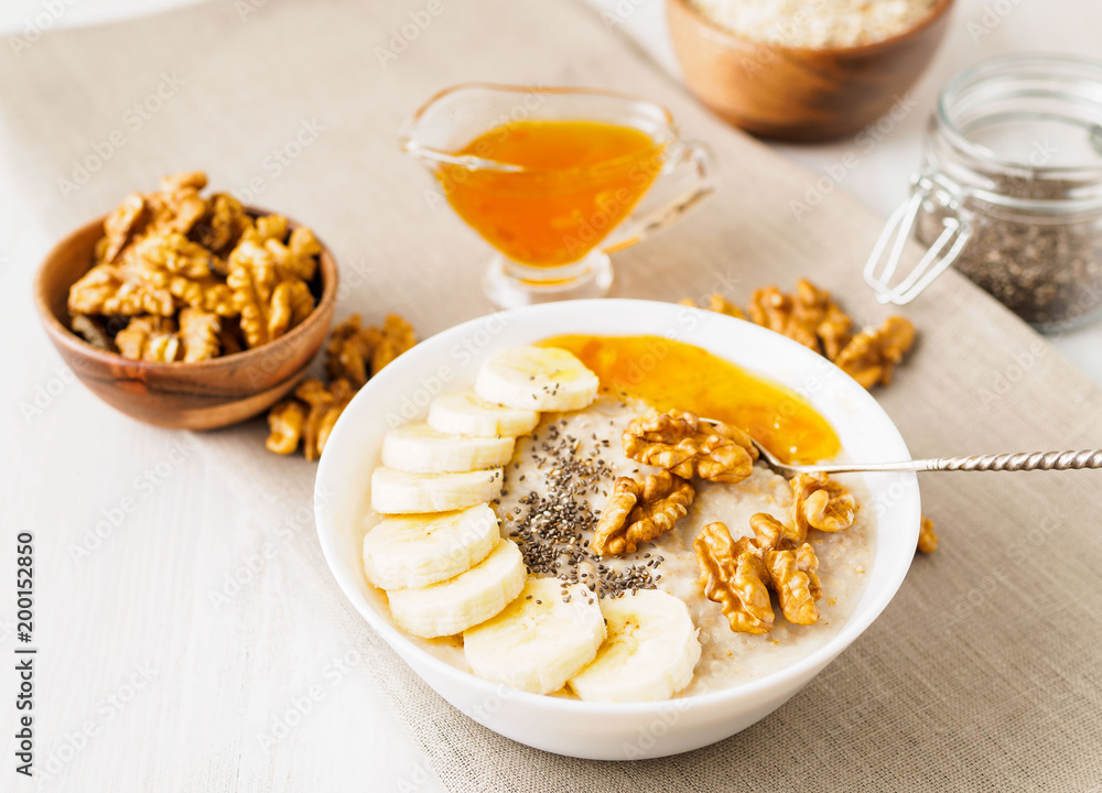 healthy breakfast - oatmeal with nuts, bananas, chia, mango jam, side view, close up healthy breakfast - oatmeal with nuts, bananas, chia, mango jam, side view, close up