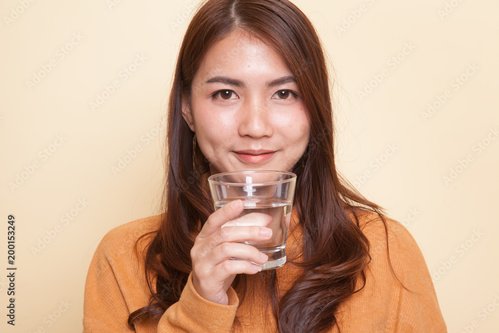 Young Asian woman with a glass of drinking water. Young Asian woman with a glass of drinking water.