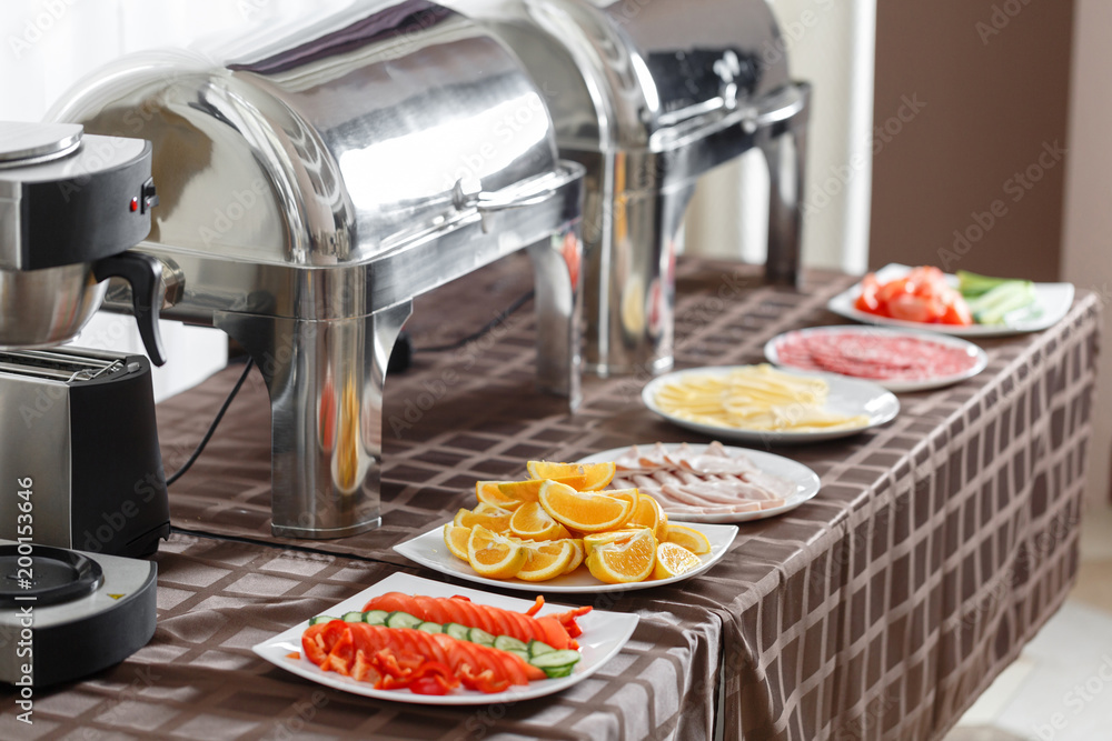 Buffet trays heated ready for service. Breakfast in hotel smorgasbord. Plates with different food Buffet trays heated ready for service. Breakfast in hotel smorgasbord. Plates with different food