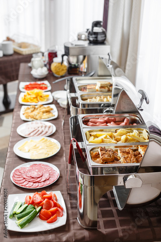 Buffet trays heated ready for service. Breakfast in hotel smorgasbord. Plates with different food