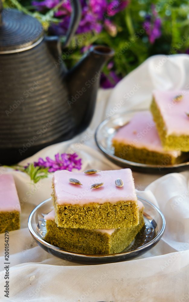 Matcha green tea cakes with white chocolate glaze seeds with tea on the white background Matcha green tea cakes with white chocolate glaze seeds with tea on the white background