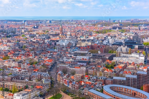 Aerial wide-angle cityscape of The Hague (Den Haag) with the North Sea and cloudy blue sky, Netherlands © larauhryn