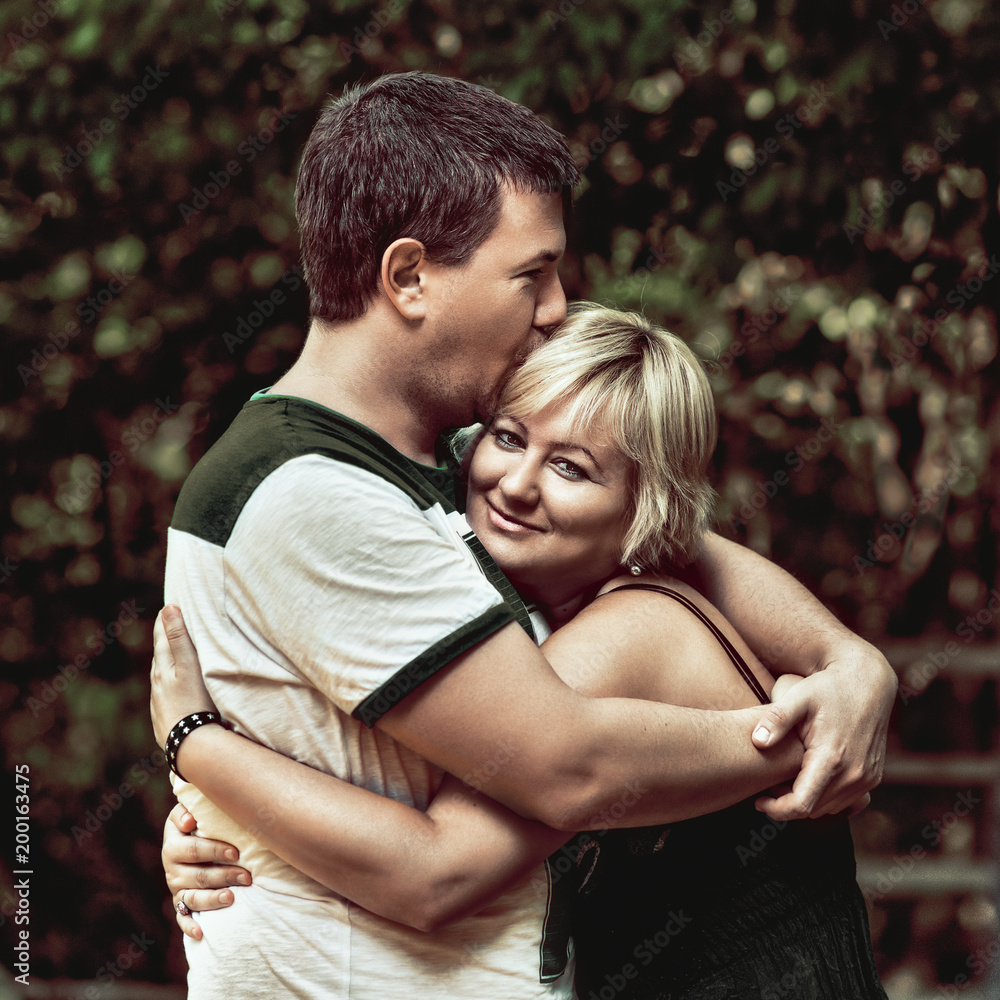 Fototapeta premium Beautiful young couple cuddling and hugging outdoors Couple cuddling and hugging outdoors, cute couple in love.