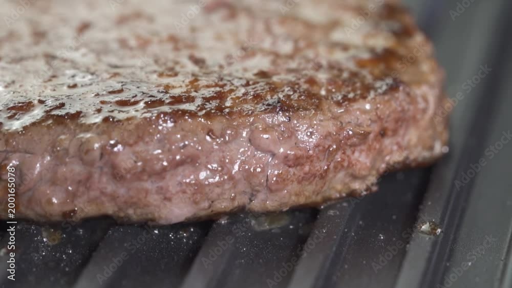 Closeup of hamburger beef cutlet on the grill - video in slow motion Closeup of hamburger beef cutlet on the grill - video in slow motion