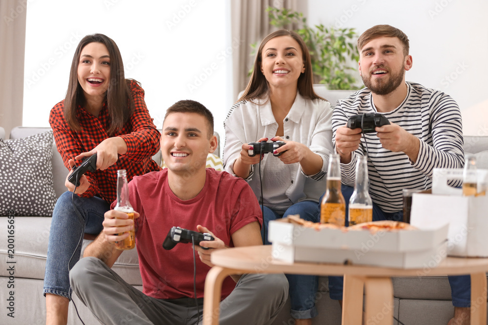 Obraz premium Młodzi ludzie grający w gry wideo w domu