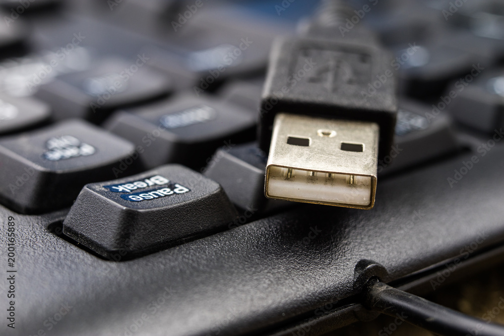 A black computer keyboard and an enlarged USB port. Computer accessories. A black computer keyboard and an enlarged USB port. Computer accessories.