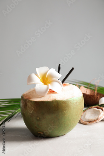 Fresh green coconut on table against gray background