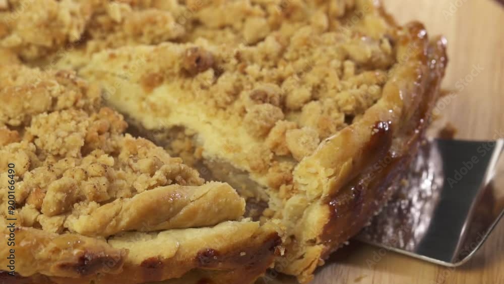Closeup hand taking away slice of fresh baked apple pie isolated from wooden plate Closeup hand taking away slice of fresh baked apple pie isolated from wooden plate