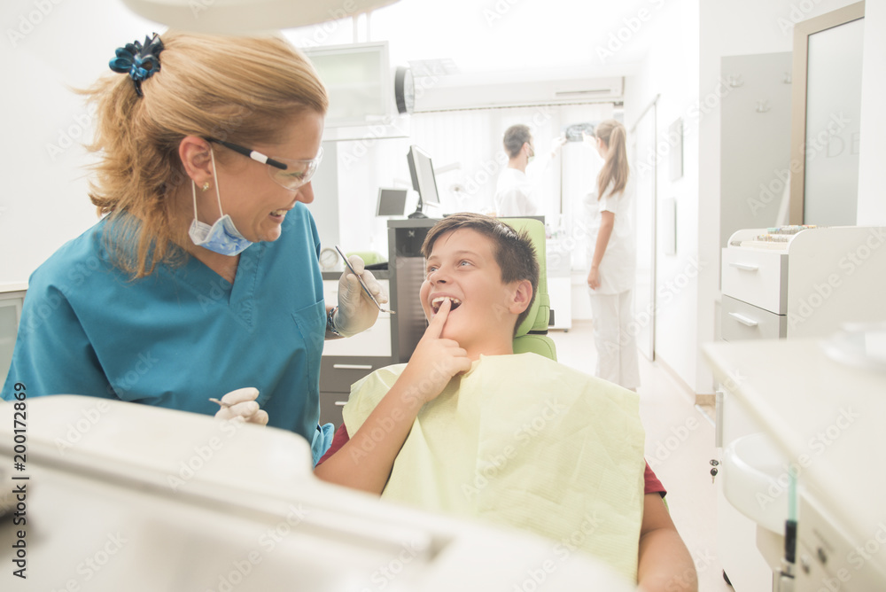 Boy with perfect teeth at the dentist doing check up with the clinic at the background - oral hygiene health care concept Boy with perfect teeth at the dentist doing check up with the clinic at the background - oral hygiene health care concept