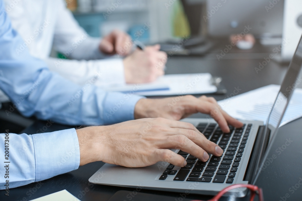 Man working with laptop in office, closeup Man working with laptop in office, closeup