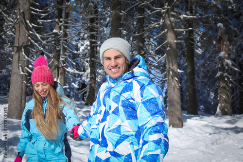 Happy couple walking in sno...