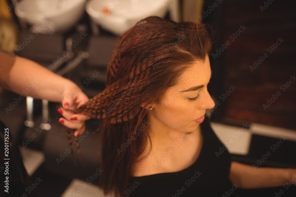 Woman styling her hair at saloon Woman styling her hair at saloon