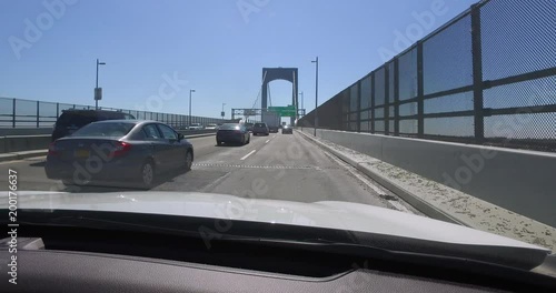 New York City, Circa 2018: Driving plate forward POV angle view traffic over New York City suspension bridge during day time rush hour commute.