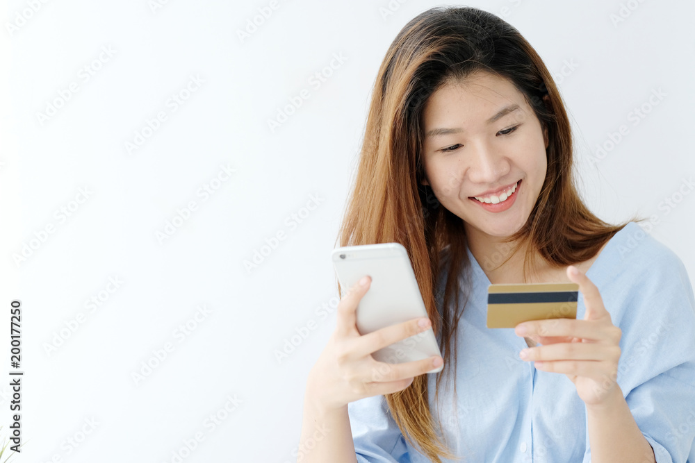 Young asian woman holding credit card and using smart phone for shopping online, business and technology concept, online payment, digital money Young asian woman holding credit card and using smart phone for shopping online, business and technology concept, online payment, digital money