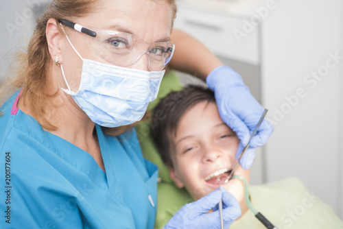Boy polishing his teeth at the dentist - oral hygiene health care concept