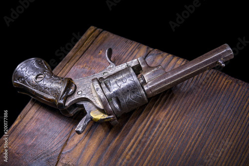 old mini revolver on wood background
