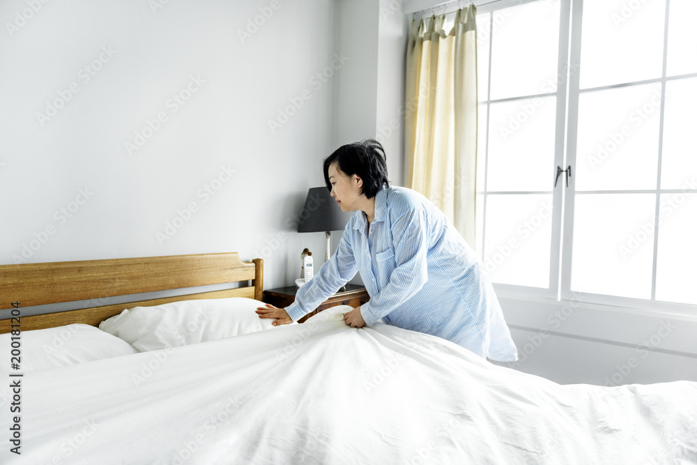 Obraz premium A woman making bed