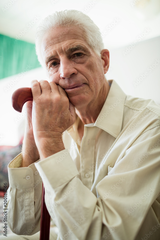 Thoughtful senior man sitting with a cane Thoughtful senior man sitting with a cane