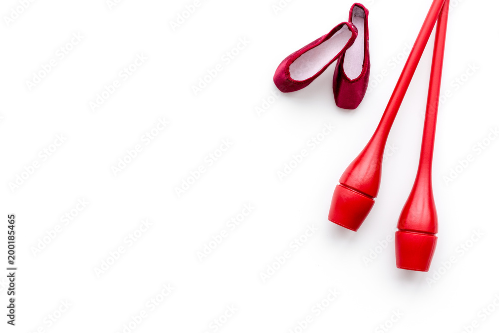 Beauty sport for girls concept. Maces for rhythmic gymnastics and ballet shoes on white background top view copy space Beauty sport for girls concept. Maces for rhythmic gymnastics and ballet shoes on white background top view copy space