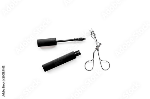 Basic products for eyelashes makeup. Mascara and eyelash curler on white background top view copy space