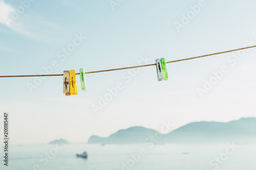 Colorful clothes pegs on blue sky © Sanga