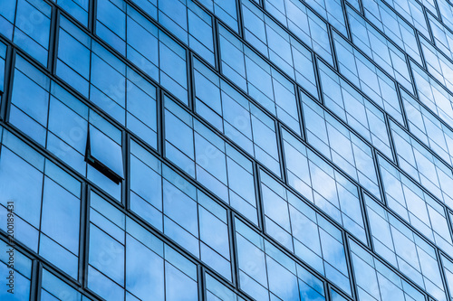 Glass wall of business center and sky reflection.