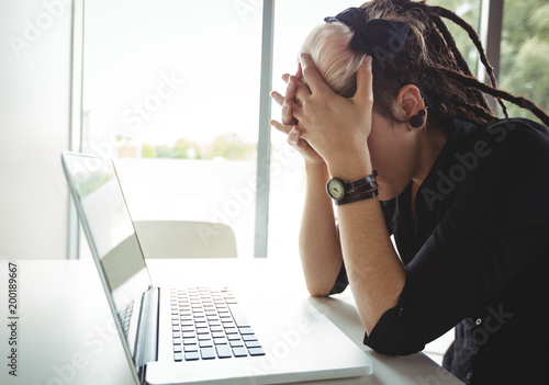 Stressed woman using laptop photo