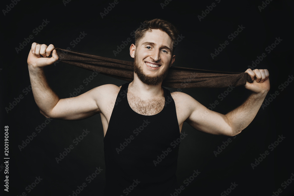 Happy sportsman holding a towel in hands and smilling. Happy sportsman holding a towel in hands and smilling.