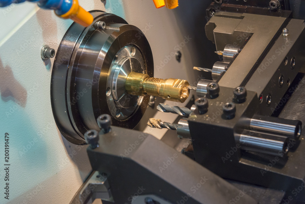 The CNC lathe machine cutting the brass shaft with the drill tool. The CNC lathe machine cutting the brass shaft with the drill tool.