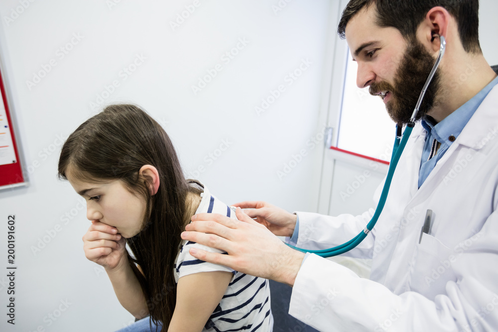 Doctor examining a sick girl