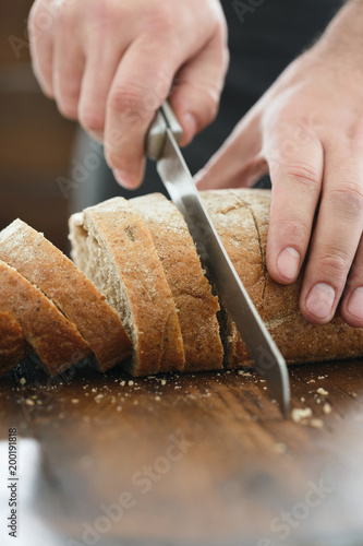 Male hands chopped fresh bread close up